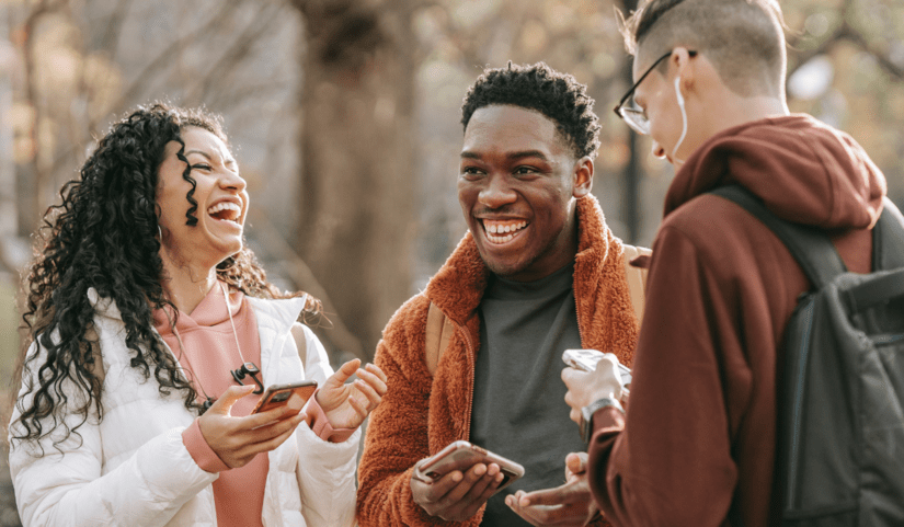 Étudiants échangeant et riant ensemble lors d’un moment convivial en extérieur